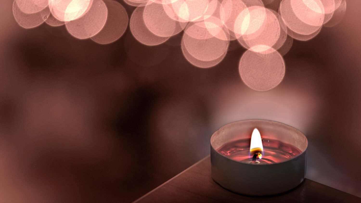 pink candle lit up on the black background