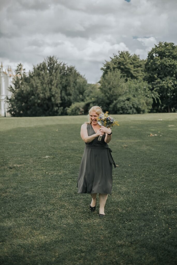 blonde woman in a emerald dress carrying a bouquet 