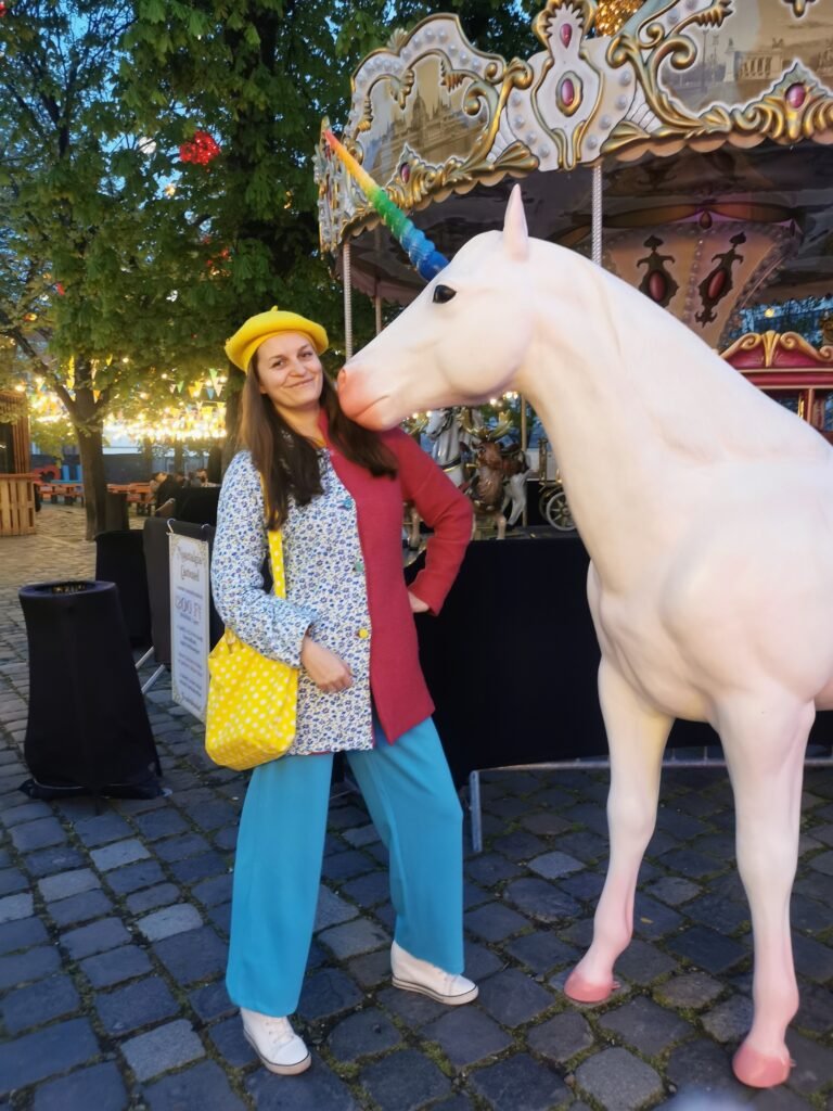 Difference between style and fashion picture - the girl 
wearing colorful clothes standing next to a unicorn 