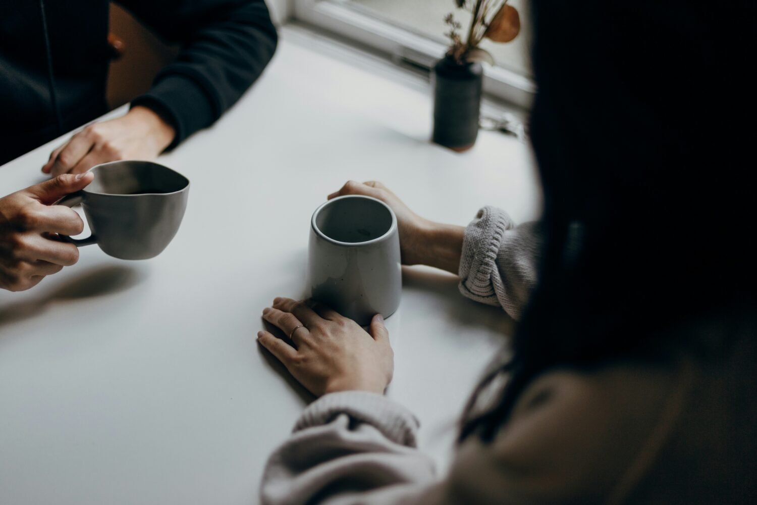 man and woman talking at the table with cups of coffee