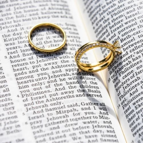 wedding rings on the opened Bible symbolising the answer to the question: Is marriage a Christian concept