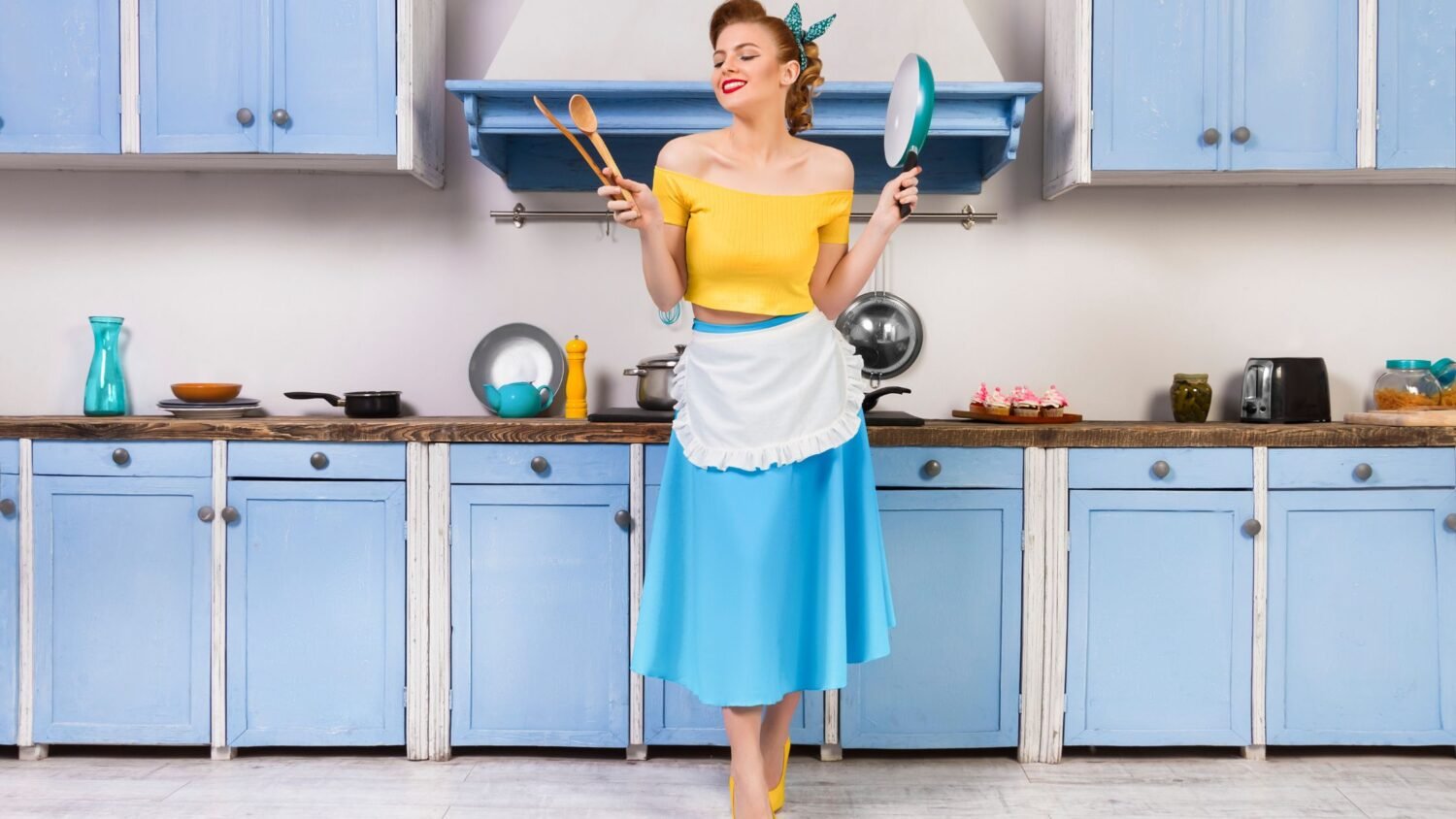 retro housewife showing what is homemaking smiling in pastel blue kitchen